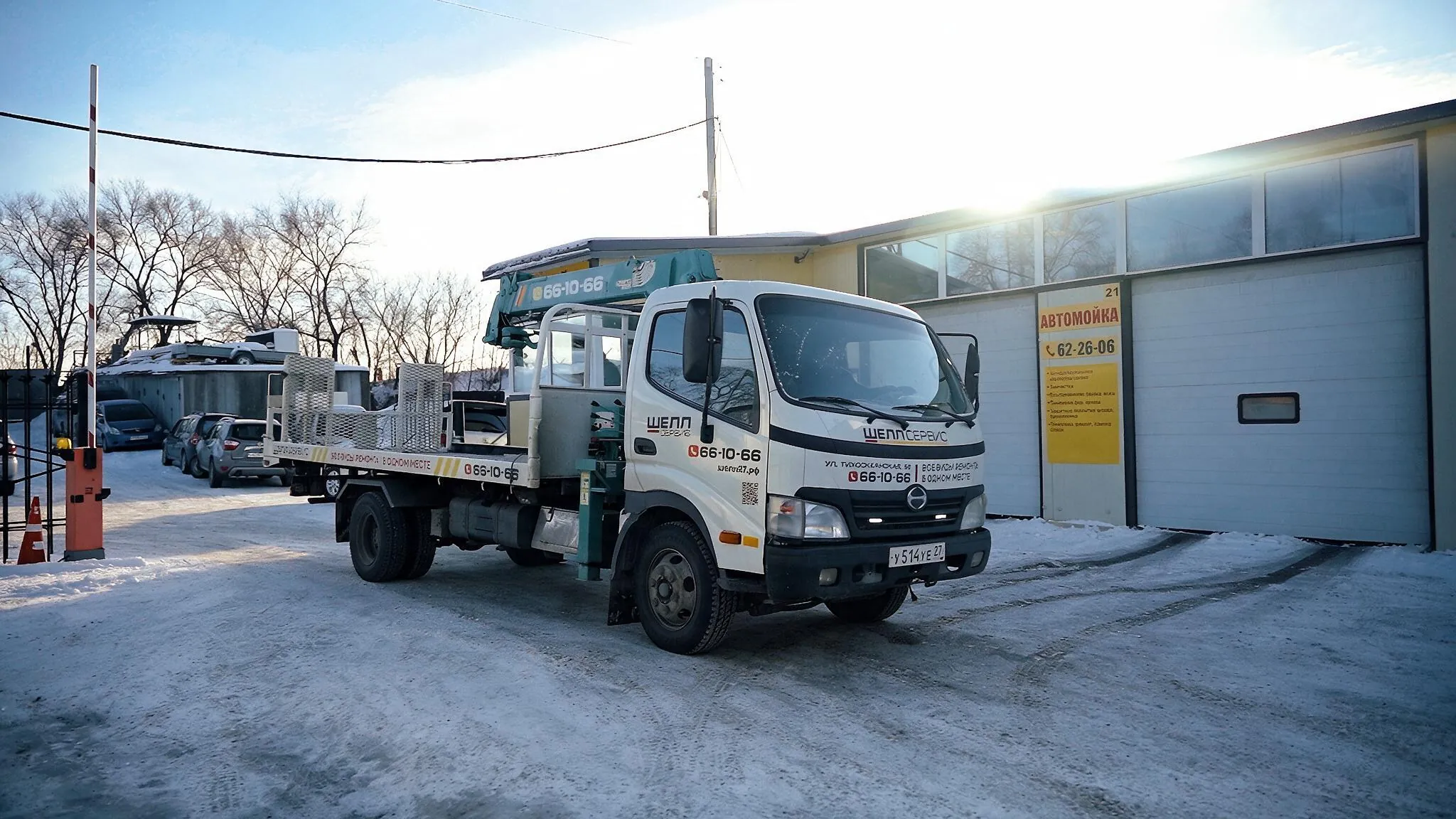 Эвакуатор ШЕЛЛ СЕРВИС с платформой во дворе автотехцентра, рядом въезд на автомойку